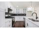 Modern kitchen with white cabinets, stainless steel appliances, and dark herringbone backsplash at 1863 Bruce Ne Rd, Atlanta, GA 30329