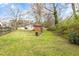 The backyard has green grass, mature trees, and an outbuilding with a wood fence at 2285 Bascomb Carmel Rd, Woodstock, GA 30189