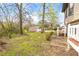 The backyard has green grass, mature trees, an outbuilding, and a concrete patio with a bench at 2285 Bascomb Carmel Rd, Woodstock, GA 30189