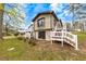 Back exterior of a cozy home with multiple decks and lovely landscaping at 2285 Bascomb Carmel Rd, Woodstock, GA 30189