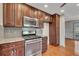 Kitchen featuring stainless steel oven, microwave, and dark wood cabinets with tiled backsplash at 2285 Bascomb Carmel Rd, Woodstock, GA 30189