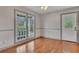 Bright room featuring hardwood floors, gray wainscoting, large windows, and an exterior door at 2285 Bascomb Carmel Rd, Woodstock, GA 30189