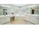 Bright bathroom featuring double sink vanity, a soaking tub beneath windows, and a separate shower and walk-in closet at 3272 Creek E Trce, Powder Springs, GA 30127