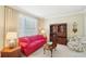 Comfortable living room with a red sofa, patterned armchair, and natural light from a large window at 3272 Creek E Trce, Powder Springs, GA 30127
