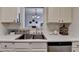 Well-lit kitchen with stainless steel sink, white cabinets and view into the living room at 5835 Terremont Cir, Norcross, GA 30093