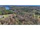 Aerial shot showcasing a house by the lake amongst dense forest with trees in autumn at 121 Rising Star Rd, Fayetteville, GA 30215