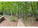 Secluded backyard haven featuring a stone path, lush greenery and wooded scenery at 121 Rising Star Rd, Fayetteville, GA 30215