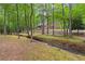 Scenic backyard view showcases the home's frontage, serene landscaping, and a tranquil creek at 121 Rising Star Rd, Fayetteville, GA 30215