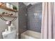 Modern bathroom with gray tiled walls, a tub, and decorative shelves for storage and decor at 121 Rising Star Rd, Fayetteville, GA 30215