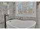 Close-up of an elegant bathroom with a soaking tub and chandelier at 121 Rising Star Rd, Fayetteville, GA 30215