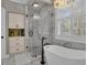 Elegant main bathroom suite featuring a soaking tub, glass enclosed shower, marble surround, and chandelier at 121 Rising Star Rd, Fayetteville, GA 30215