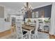Elegant dining room with a modern chandelier, hardwood floors, white wainscoting, and access to the kitchen at 121 Rising Star Rd, Fayetteville, GA 30215