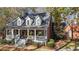 Stately brick home with a charming front porch, dormer windows, and professional landscaping at 121 Rising Star Rd, Fayetteville, GA 30215