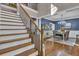 Staircase and dining area in this home featuring hardwood floors, and blue accent wall in the dining room at 121 Rising Star Rd, Fayetteville, GA 30215