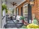 Comfortable front porch with seating area, ceiling fan, and decorative plants and flowers at 121 Rising Star Rd, Fayetteville, GA 30215