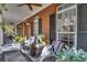 Spacious front porch with ample seating, ceiling fans, and decorative plants and flowers at 121 Rising Star Rd, Fayetteville, GA 30215
