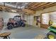 Large unfinished garage used for storage with an ATV and lawn mower at 121 Rising Star Rd, Fayetteville, GA 30215