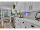 Bright kitchen with white cabinets, marble countertops, stainless steel oven, and hardwood floors leading to a dining area at 121 Rising Star Rd, Fayetteville, GA 30215