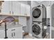 Functional laundry room with stacked washer/dryer, granite countertop, storage cabinets, and stylish decor at 121 Rising Star Rd, Fayetteville, GA 30215