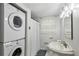 Compact bathroom featuring a stackable washer and dryer, a vanity sink, and a shower with white curtain at 205 Glencourtney Dr, Sandy Springs, GA 30328