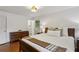 Bedroom featuring a queen-sized bed, hardwood floors, bedside table, and a full dresser against the wall at 205 Glencourtney Dr, Sandy Springs, GA 30328