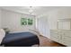 Bedroom with hardwood floors, a bed, white dresser, and closet providing a comfortable and functional space at 205 Glencourtney Dr, Sandy Springs, GA 30328