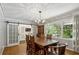 Sunlit dining room with hardwood floors, barn doors, and large windows overlooking the yard at 205 Glencourtney Dr, Sandy Springs, GA 30328