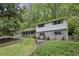 Charming two-story home with light gray brick and white siding nestled among mature trees at 205 Glencourtney Dr, Sandy Springs, GA 30328