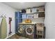 Functional laundry room with washer, dryer, storage shelves, and utility sink at 205 Glencourtney Dr, Sandy Springs, GA 30328