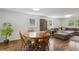 Open-concept living room featuring hardwood floors, dining table, comfortable sofa, and ample natural light at 205 Glencourtney Dr, Sandy Springs, GA 30328