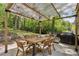 Outdoor patio with dining table and grill, perfect for entertaining in a private wooded setting at 205 Glencourtney Dr, Sandy Springs, GA 30328