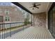 Spacious covered balcony with ceiling fan, railing and brick accent wall overlooking a yard at 269 Devin Ne Pl, Atlanta, GA 30305
