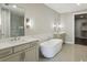 Modern bathroom with dual sinks, soaking tub, and a glass-enclosed shower; enhanced by neutral color palette at 269 Devin Ne Pl, Atlanta, GA 30305