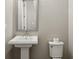 A half bathroom with a pedestal sink, toilet, and neutral tones at 269 Devin Ne Pl, Atlanta, GA 30305