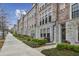 Brick townhome featuring a sidewalk, black trim windows, and manicured landscaping at 269 Devin Ne Pl, Atlanta, GA 30305