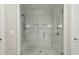 Contemporary shower featuring marble-style tiles, a built-in bench, and a sleek glass door at 269 Devin Ne Pl, Atlanta, GA 30305