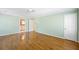 A spacious bedroom featuring hardwood floors, three windows, light green walls, and access to a bathroom at 5269 Wyntercreek Dr, Atlanta, GA 30338