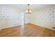 Elegant dining room with hardwood floors, chandelier, and stylish wallpaper at 5269 Wyntercreek Dr, Atlanta, GA 30338