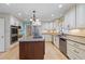 Kitchen with stainless steel appliances, light countertops, white cabinets, island with gas cooktop and wood floors at 5269 Wyntercreek Dr, Atlanta, GA 30338