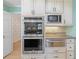 Kitchen appliances including built in oven and microwave, light countertops, backsplash, and white cabinets at 5269 Wyntercreek Dr, Atlanta, GA 30338