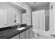 Well-lit bathroom with granite counters, cabinets and shower with white tile and shower curtain at 1228 Church St, Decatur, GA 30030