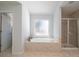 Bright bathroom with a soaking tub under a window, separate glass shower, and tile floor at 1871 Shiloh Valley Nw Way, Kennesaw, GA 30144