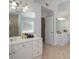 Primary bathroom with dual vanities, tile floors, two mirrors, and a door leading to a closet at 1871 Shiloh Valley Nw Way, Kennesaw, GA 30144