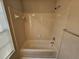 Bathroom features a bathtub with shower and a tiled wall and window at 6406 Laurel Post Dr, Lithonia, GA 30058