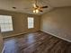 Spacious bedroom featuring wood-look flooring, two windows, and a ceiling fan with lights at 6406 Laurel Post Dr, Lithonia, GA 30058