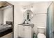 This bathroom has a white vanity with a round mirror and modern fixtures, with bedroom view at 1065 United Ave # 208, Atlanta, GA 30316