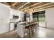 Modern kitchen with stainless steel appliances, marble backsplash, an island with bar seating, and exposed pipes at 1065 United Ave # 208, Atlanta, GA 30316
