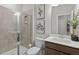 This bathroom features a glass enclosed shower, decorative art, and a sleek single sink vanity at 1613 Caldwell Bend Ln, Dacula, GA 30019