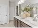 The bathroom includes a double sink vanity, a walk-in shower, and natural accents at 1613 Caldwell Bend Ln, Dacula, GA 30019