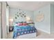 Stylish bedroom with a blue comforter, decorative wall hangings and neutral carpet at 1613 Caldwell Bend Ln, Dacula, GA 30019